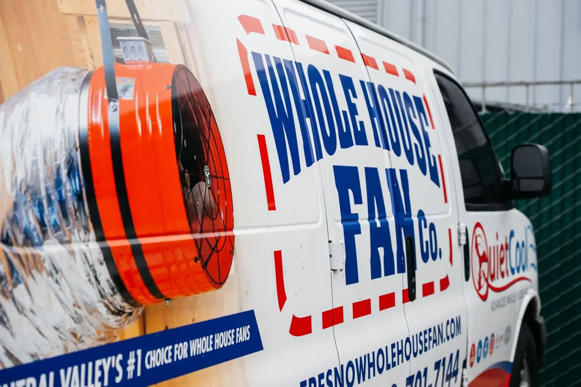 Whole House Fan Co. van beside a large orange whole house fan unit
