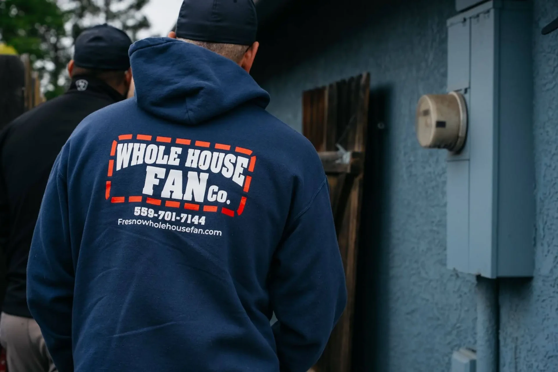 Whole House Fan Co. technician in branded hoodie at a customer's home